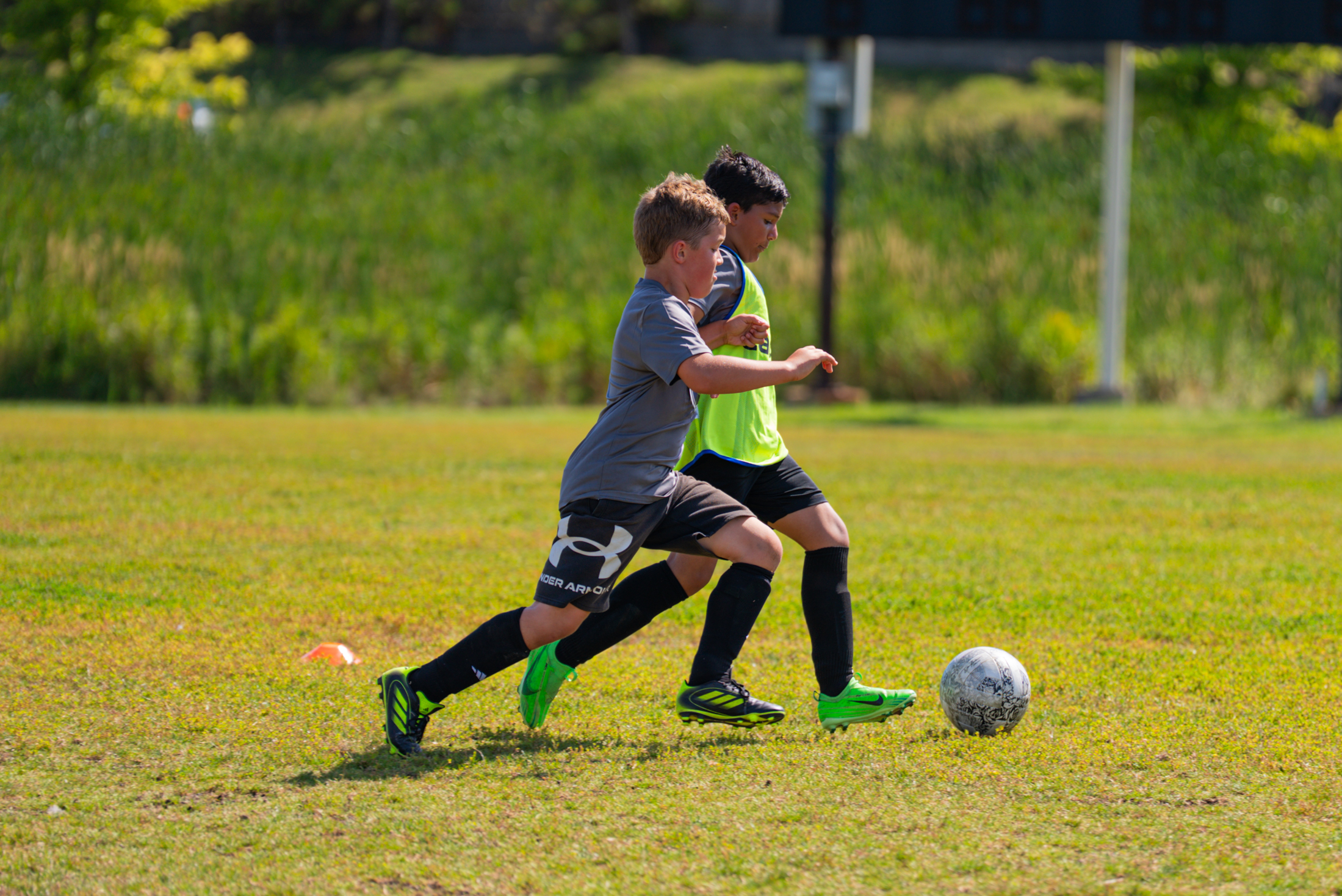 Two kids playing soccer outside