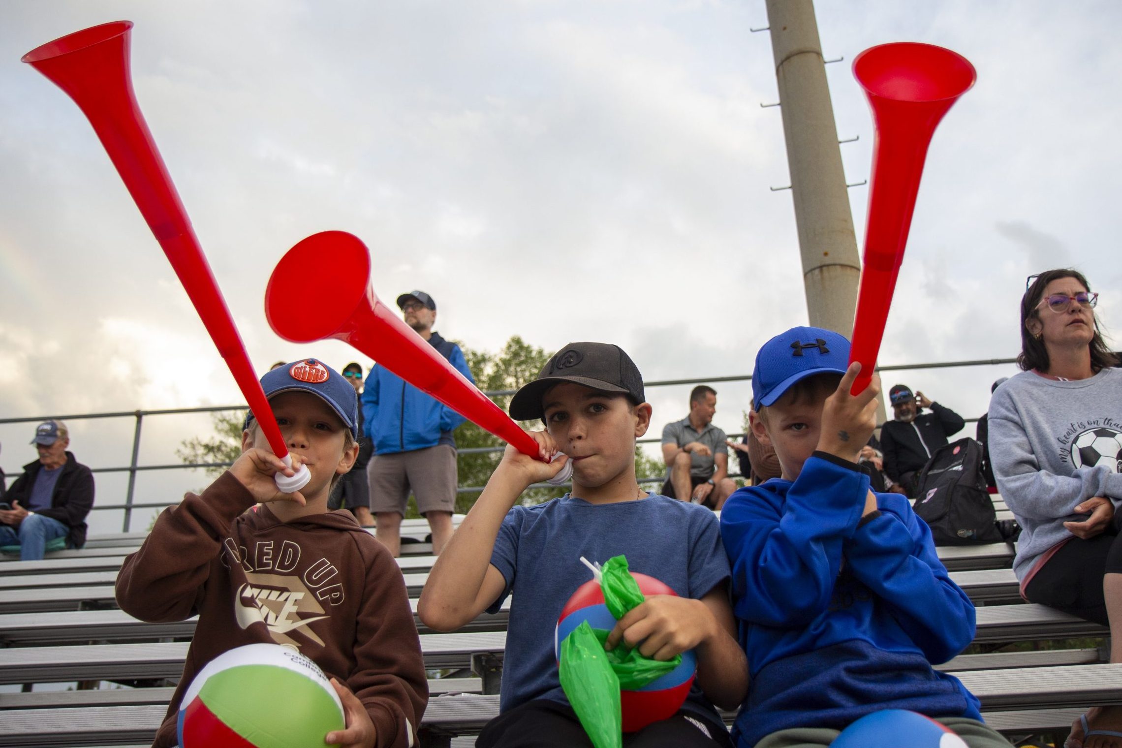 Three kids holding vuvuzelas